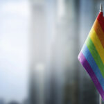 LGBTQIA+ Workplace Discrimination Examples: Small national flags of the lgbtqia+ on a light blurry background